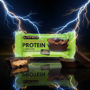 Copos de manteiga de proteína NUTRYNUTS de 42g com sabor cremoso, exibindo os ingredientes e embalagem do produto.